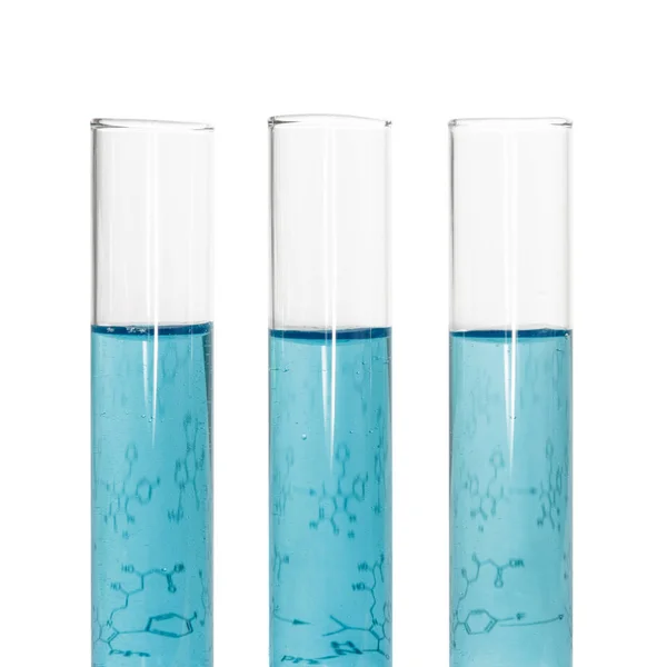 Three test tubes with blue liquids and sheet of paper — Stock Photo, Image