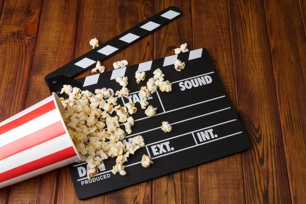 Black with white letters poppers, box of popcorn spilled on dark — Stock Photo, Image