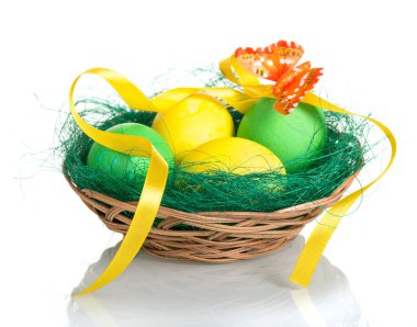 Colored Easter eggs in basket, butterfly and ribbon on white .