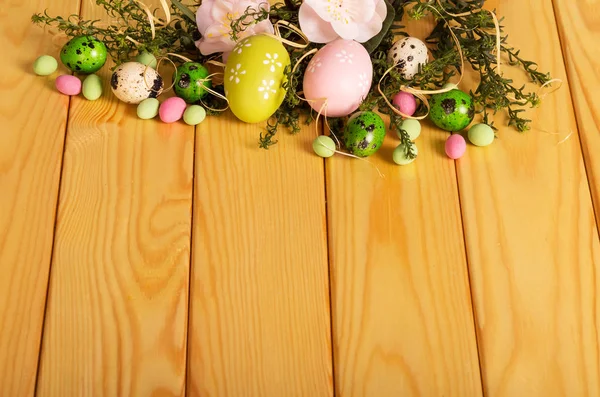 Colored Easter eggs, flowers, candy, grass on background light — Stock Photo, Image