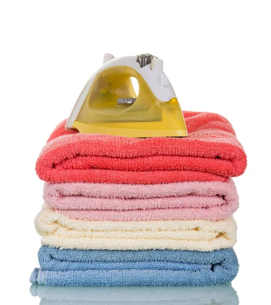 Stack of folded towels and an iron isolated on white — Stock Photo, Image