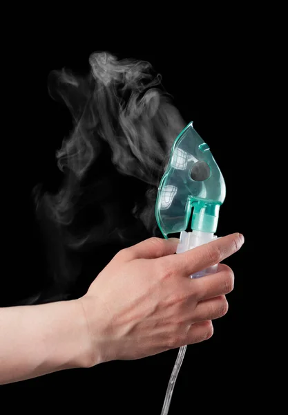 Mask inhaler with medication in hand isolated on black — Stock Photo, Image