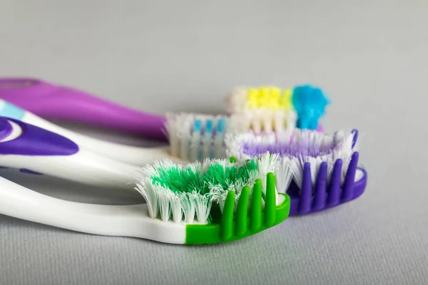灰色背景下的不同类型的牙刷 — 图库照片