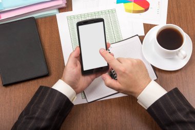 Elinde akıllı telefon tutan bir ofis çalışanı.