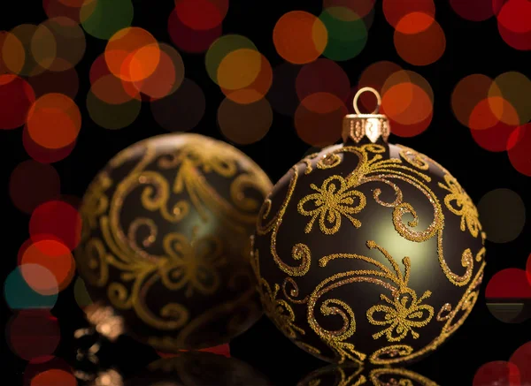Δύο Όμορφες Χριστουγεννιάτικες Μπάλες Διακοσμημένες Σχέδια Βρίσκονται Σκούρο Λαμπερό Φόντο — Φωτογραφία Αρχείου