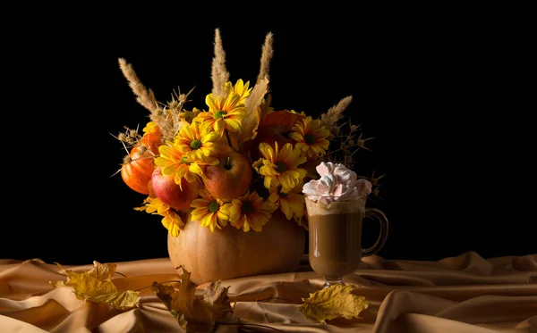 Strauß Herbstblumen in Kürbis und Latte auf drapiertem Stoff — Stockfoto