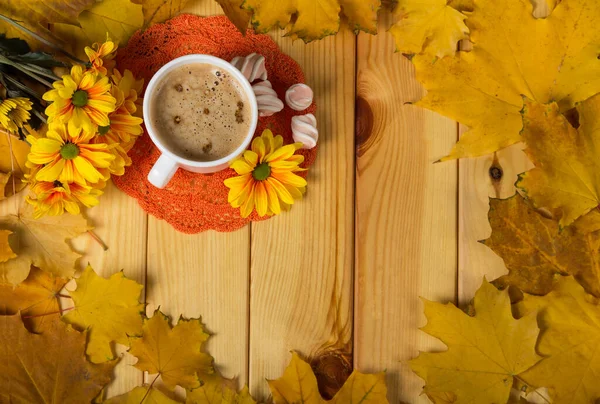 Tasse mit Kaffee und Süßigkeiten auf dem Tisch im Rahmen der Herbstblätter — Stockfoto