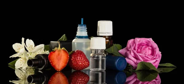 Conjunto de líquidos perfumados para fumar cigarros eletrônicos, bagas e flores isoladas em preto — Fotografia de Stock