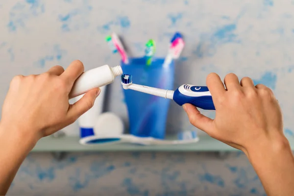 Primer plano de las manos y pasta de dientes en el cepillo — Foto de Stock