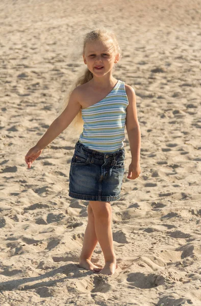 Charming blond girl walking along sandy beach — 스톡 사진