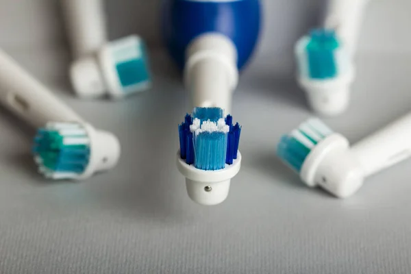 Elektrický kartáček na zuby a vyjímatelné trysky na šedé — Stock fotografie