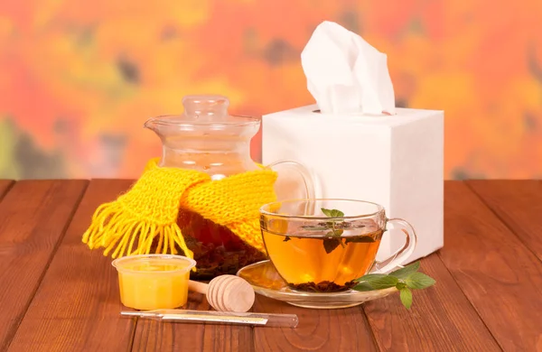 Waterkoker en kopje warme thee met honing uit de koude, op tafel — Stockfoto