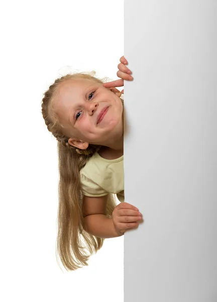 Little laughing girl peeking out from behind an empty banner — ストック写真