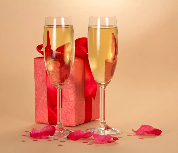 Due bicchieri celebrativi di champagne e scatola con regalo, su beige — Foto Stock