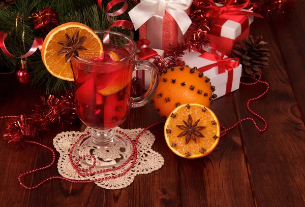 Festive warming drink and fruit boxes with gifts on table — Stock Photo, Image