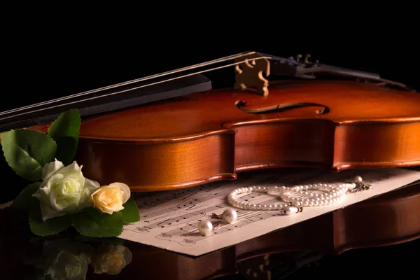 Geige und Notizblock mit Notizen, Schmuck und Blumen isoliert auf schwarz — Stockfoto