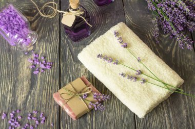 El yapımı sabun, deniz tuzu ve lavanta tentürü, ahşap yüzeyde havlu.