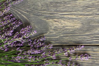 Ahşap yüzeyde tıbbi lavanta çiçekleri yatıyor.