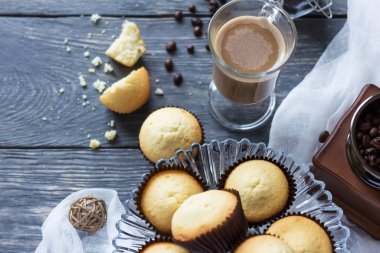 Kekler cam vazoda, kakaolar masada.