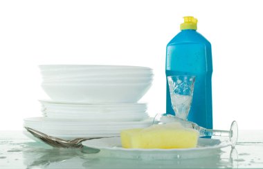Clean crockery in soapy foam, bottle with detergent and sponge isolated on white