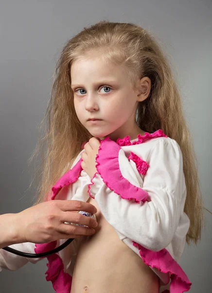 Sick child at doctor's reception, on gray — Stock Photo, Image