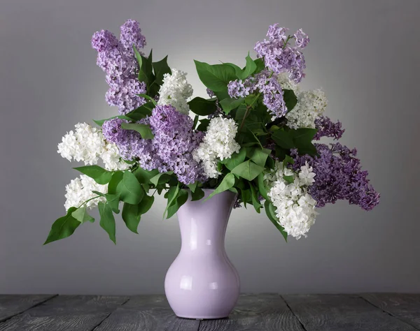 Belo buquê de flores brancas e lilás em vaso em cinza — Fotografia de Stock