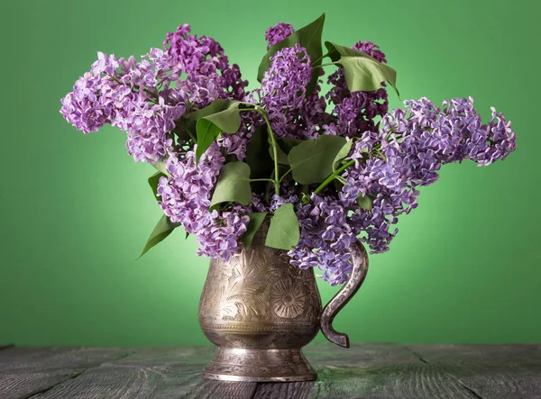 Bukiet pachnący liliowy w zabytkowym wazonie, na zielonym — Zdjęcie stockowe