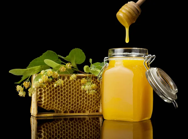 Agitador de madeira para mel e favos de mel, isolado em preto — Fotografia de Stock