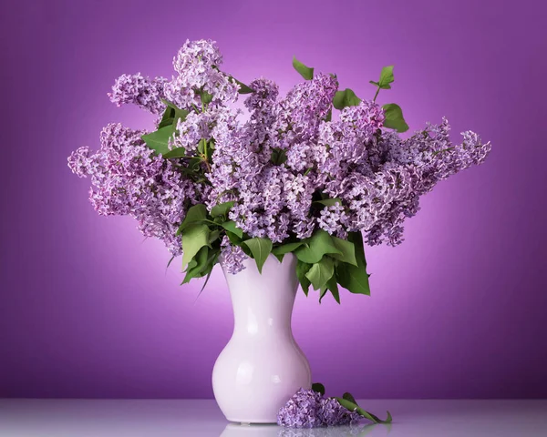 Ramo exuberante de flores en jarrón sobre fondo lila — Foto de Stock