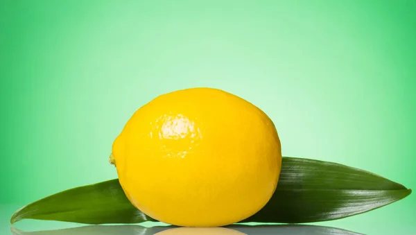 Big yellow lemon close-up, on green — Stockfoto