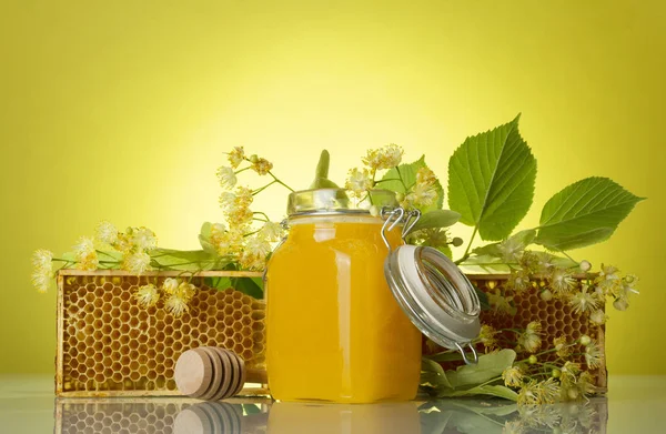 Jar of honey, wooden frame with bee honeycombs on yellow background — Stock Photo, Image