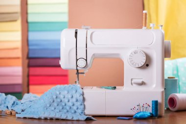 Dikiş makinesi ve kumaş, masaya dikiş malzemeleri.