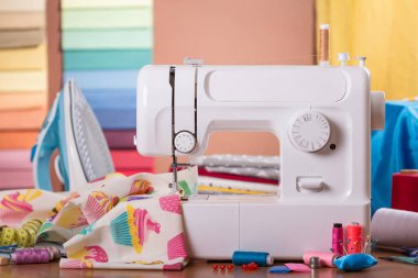 Kumaş örneklerinin arka planında, iş yerinde ve aksesuarlarda dikiş makinesi