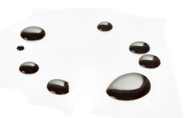 Parlak siyah eritilmiş çikolata damlaları beyaza izole edilmiş. — Stok fotoğraf