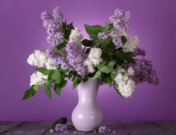 Encantador ramo de flores blancas y lila sobre fondo púrpura — Foto de Stock