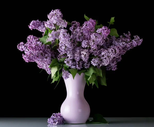 Fresh bouquet of lilac in vase isolated on black — Stock Photo, Image