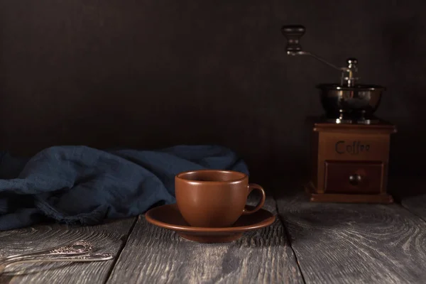 Keramische beker en schotel, theelepels, handmolen voor koffie, op zwarte achtergrond — Stockfoto