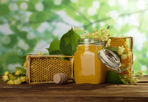 Honey in jar with lid, honeycomb on table, close-up — Stock Photo, Image