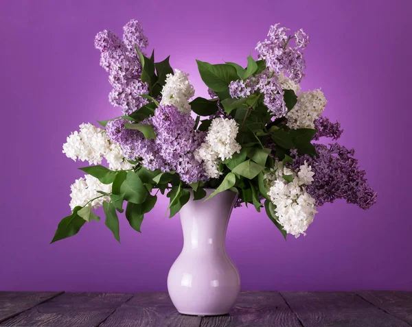 Bukett med vita och lila blommor i vas på bordet — Stockfoto