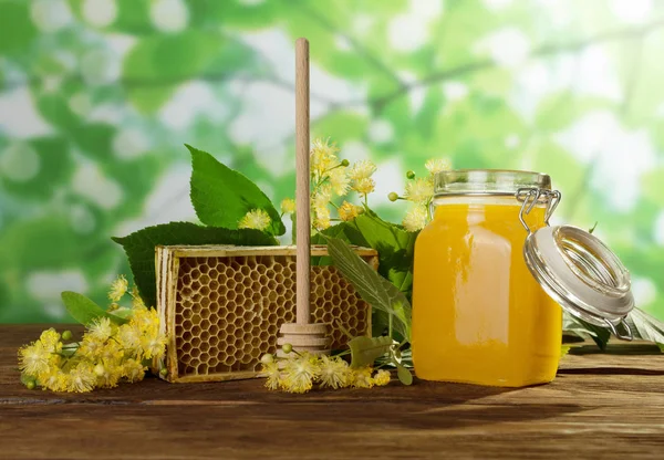 Favo de mel, jarra de mel e colher na mesa de madeira — Fotografia de Stock