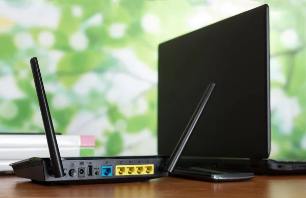 Роутер WiFi, розетка для кабельного подключения и ноутбук на столе — стоковое фото