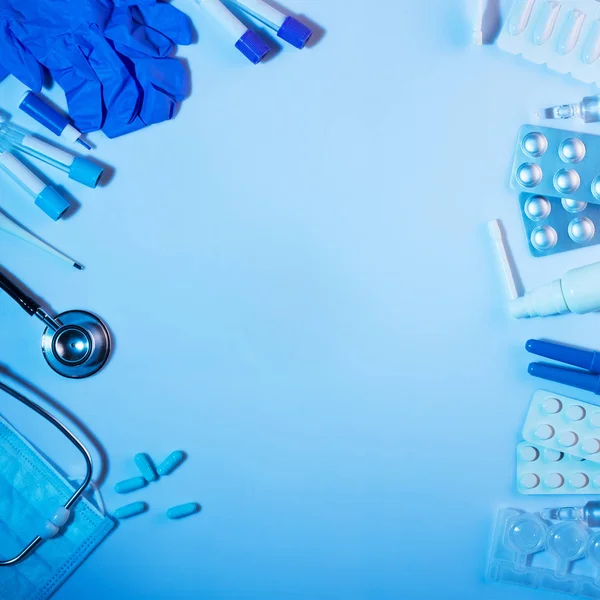 Fonendoscopio, termometro, provette e medicinali sono disposti su fondo blu — Foto Stock