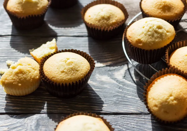 Geurige vanille cupcakes in mallen op houten oppervlak — Stockfoto