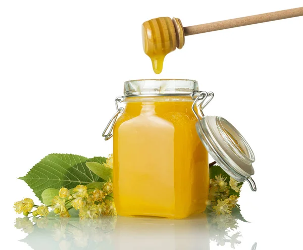 Tok zlatého medu teče ze šlehačky do sklenice, izolovaný na bílém — Stock fotografie