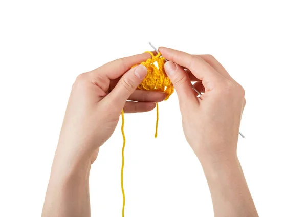 Female hands knitting with a yellow scarf isolated on white — Stock Photo, Image