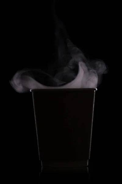 Бумажная чашка с горячим кофе. Силуэт. Изолированный на черном фоне — стоковое фото