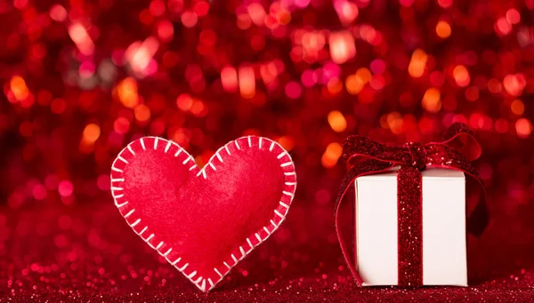 Cuore in feltro fatto a mano e regalo per San Valentino su sfondo rosso scintillante — Foto Stock