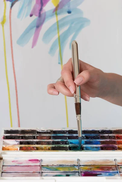 Fogalom a festészet művészetének tanításáról. Női kéz ecset akvarell festék — Stock Fotó