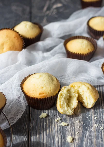 Freshly baked cupcakes in molds on background of thin airy fabric — Stock Photo, Image