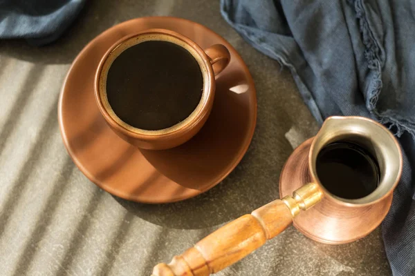 Kaffebryggare, dricka i Cup med tefat, på bord med blå trasa — Stockfoto